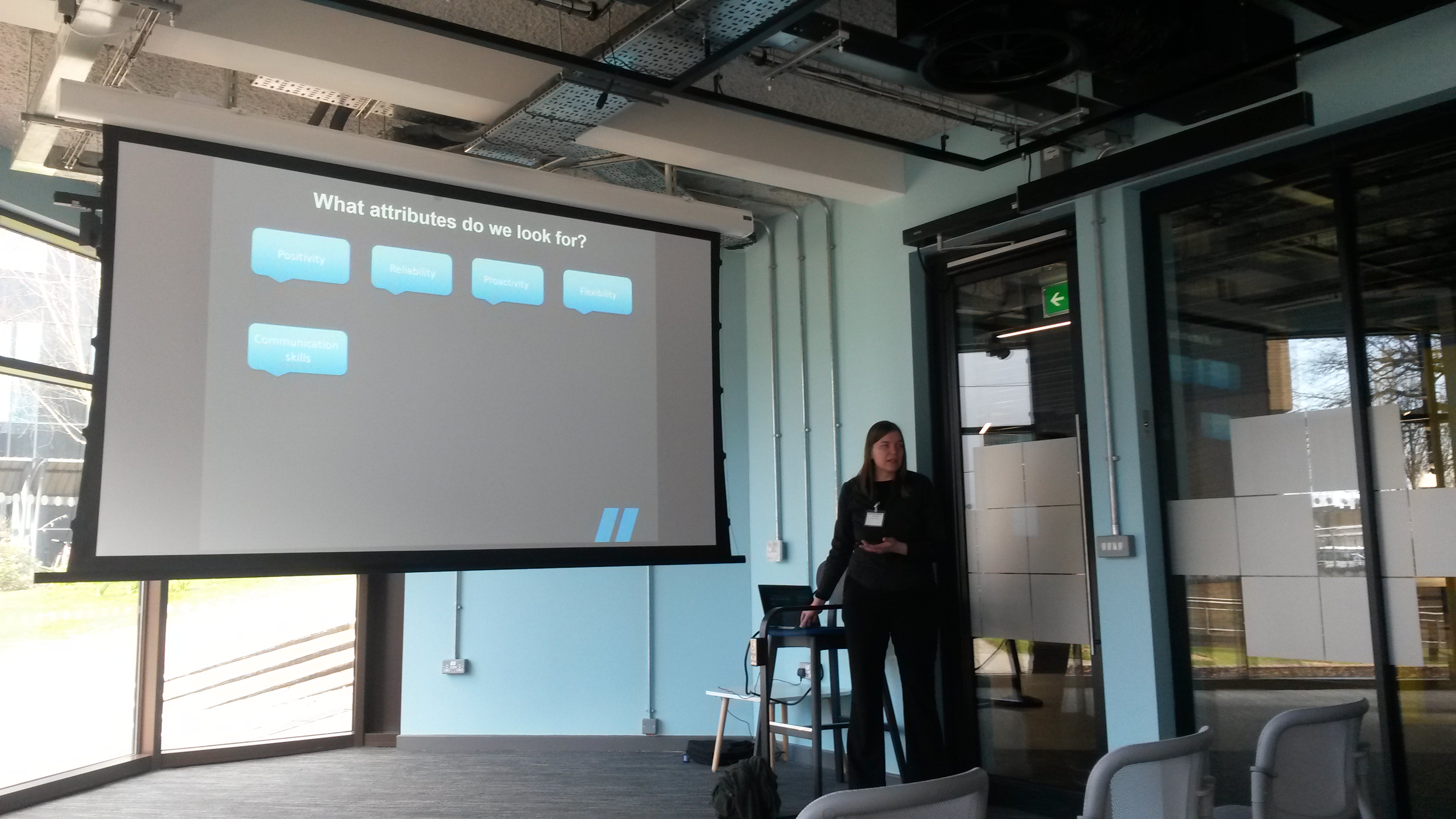 a Wolfestone employee giving a presentation in front of a powerpoint screen