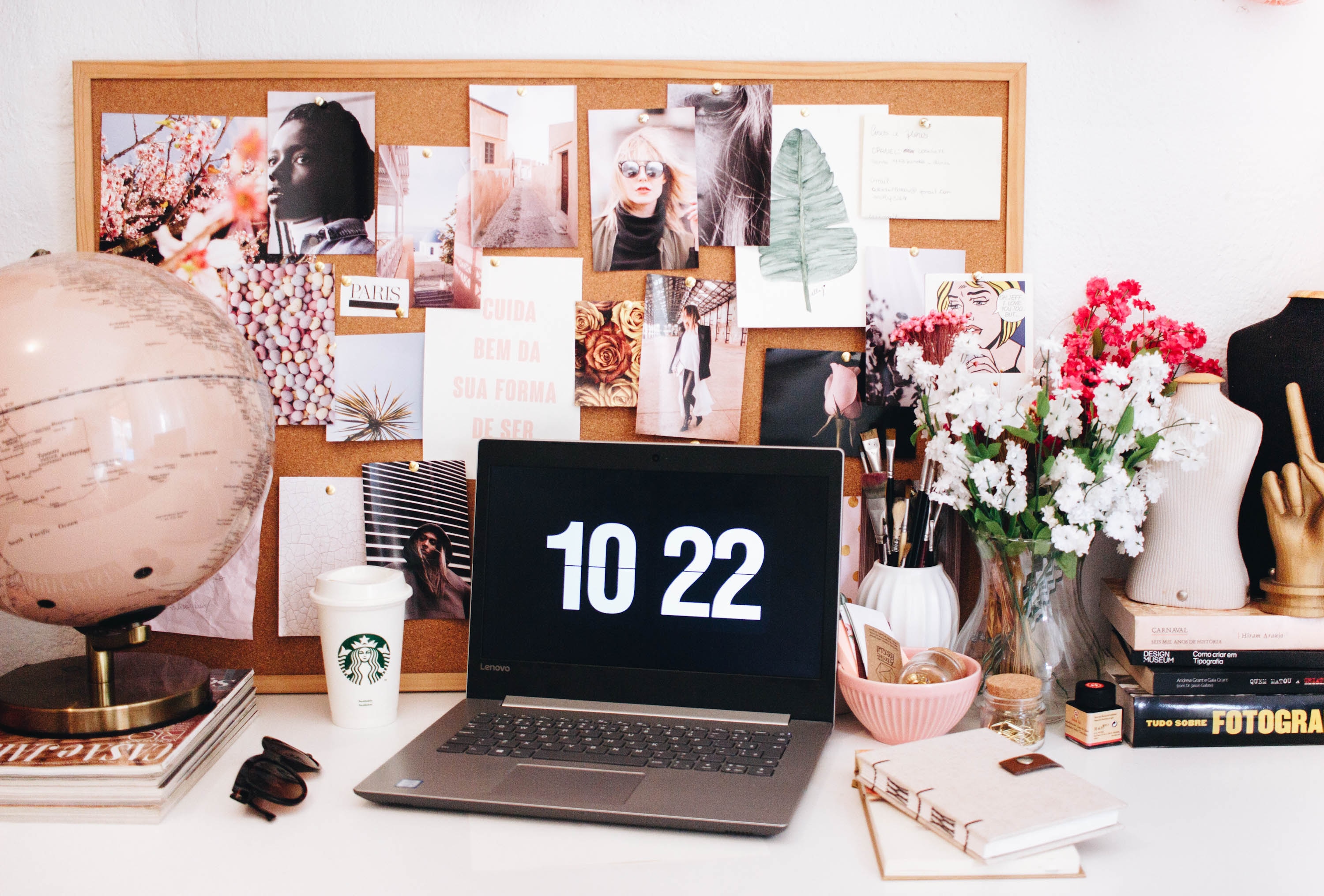 Laptop surrounded by pink items.