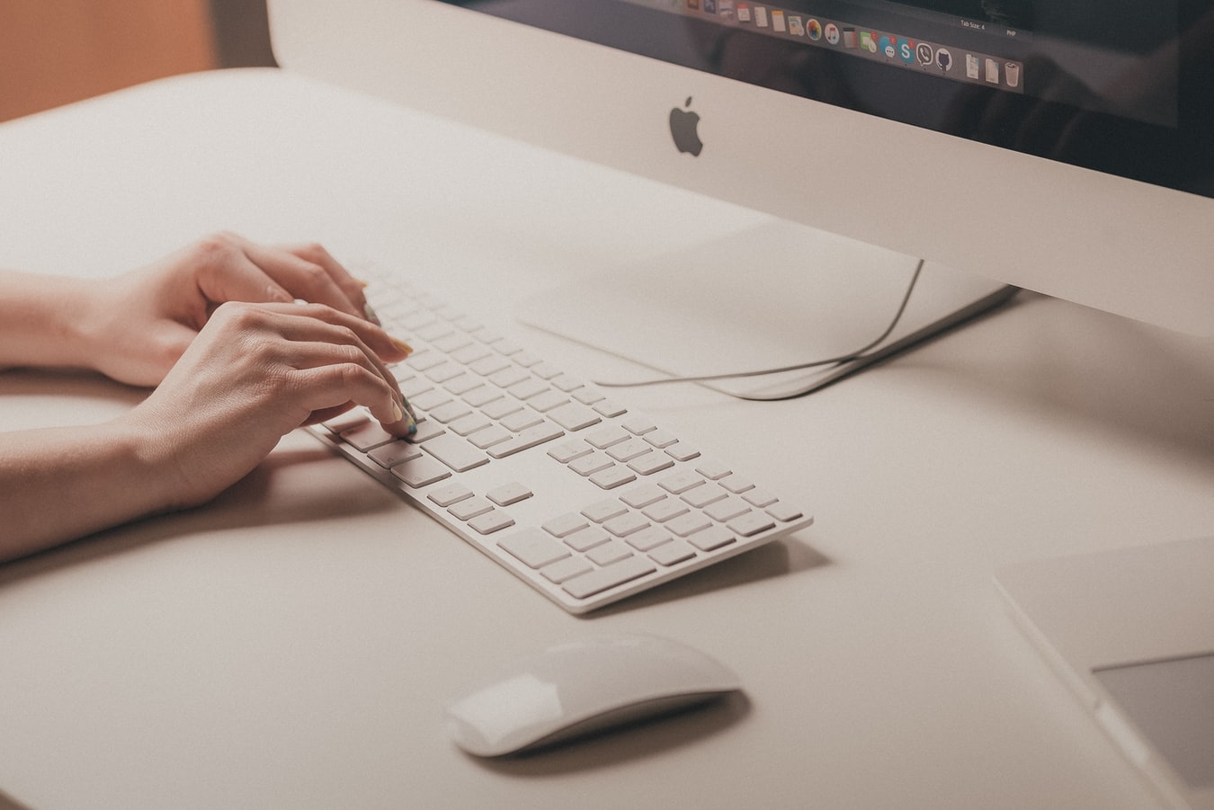 Person typing on Mac computer
