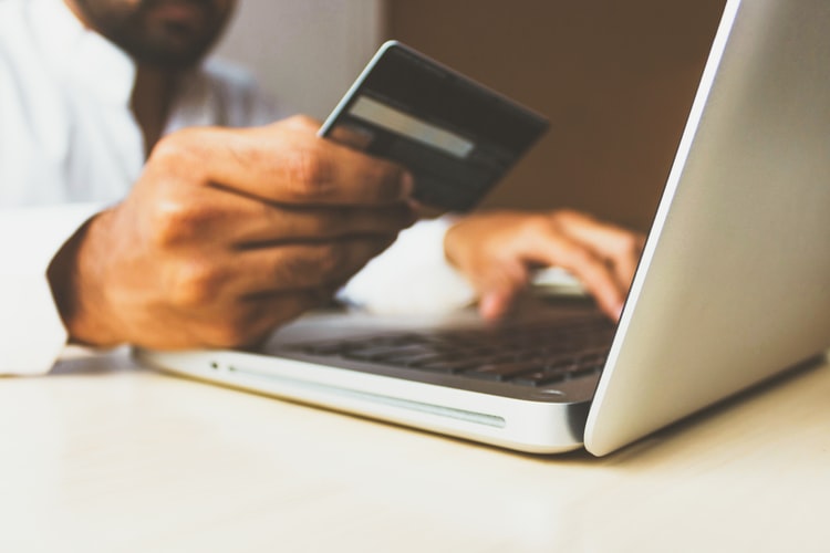 Man making purchase online holding credit card