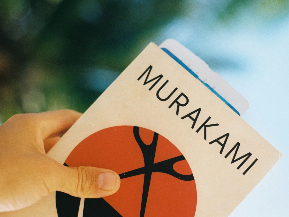 Image shows a Haruki Marukami book being held at an angle with a bookmark inside.