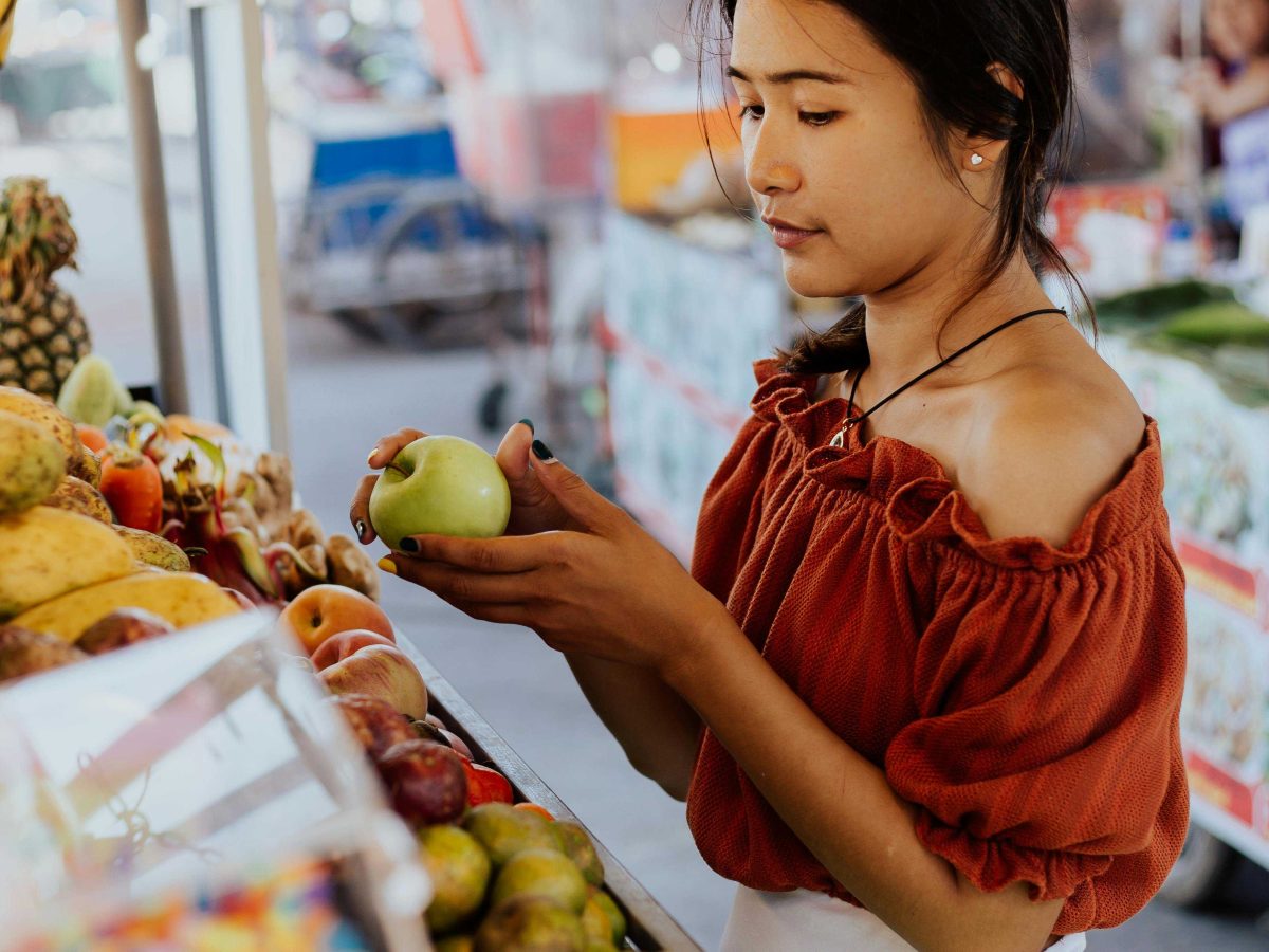 Woman in Red Top Holding a Green Apple